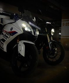 two motorcycles parked next to each other in a garage