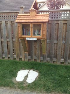 there is a small wooden book shelf in the yard