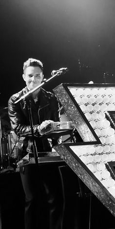 a man with headphones on playing an electric guitar in front of microphones and lights