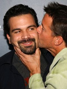 two men are kissing each other on the red carpet