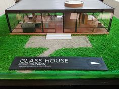 the glass house is on display in the museum's green grass flooring area