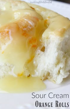 a close up of a piece of cake on a plate with oranges and cream