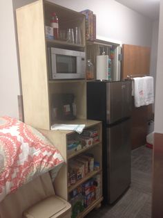 a small kitchen with a refrigerator, microwave and other items in the room that are neatly organized