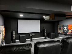 a home theater with black leather chairs and speakers