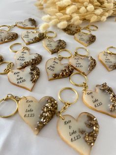 heart shaped cookies with names and date written on them sitting on a white tablecloth