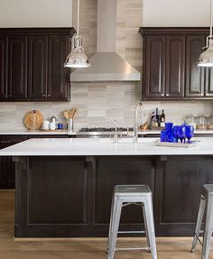 a kitchen with dark wood cabinets and white counter tops