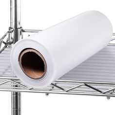 a roll of white paper sitting on top of a metal shelf