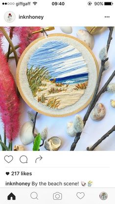 an embroidery project on the app store's facebook page, with flowers and seashells in the background