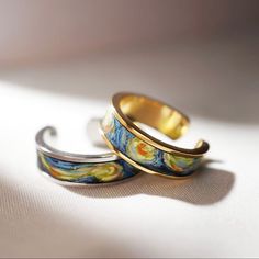 two rings sitting on top of each other with the same design painted on one side