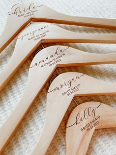 five wooden wedding hangers with names on them