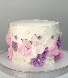 a white cake with pink and purple flowers on it