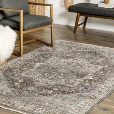 a large area rug in a living room with chairs and other items on the floor