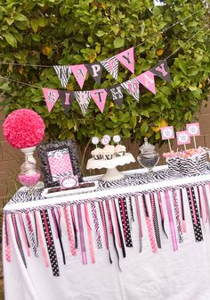 a table with pink and black decorations on it