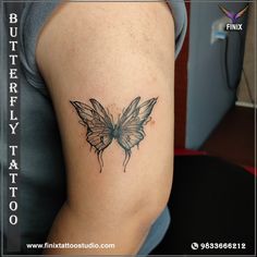 a butterfly tattoo on the back of a woman's left arm, with black ink