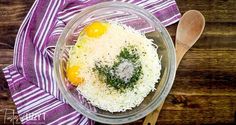 a bowl with rice, eggs and parsley in it next to a wooden spoon