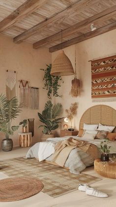 a large bed sitting in a bedroom next to a wooden table and potted plants