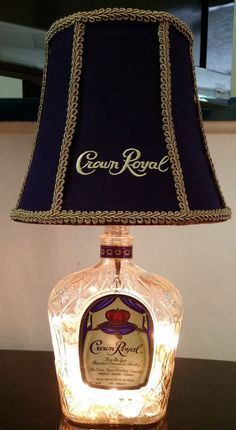 a lamp that is on top of a table with a bottle in front of it