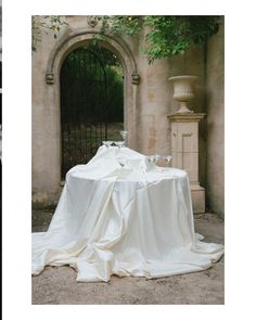 a table covered with white cloth in front of an archway