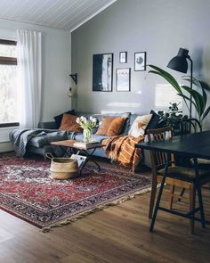 a living room with a couch, rug and pictures on the wall above it in black frames