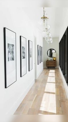 a long hallway with pictures on the wall and a video play button in the middle