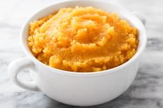 a white bowl filled with mashed potatoes on top of a table