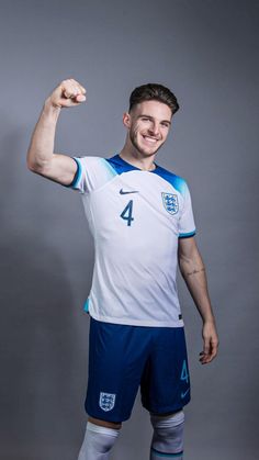 a soccer player poses for a photo in his england shirt and shorts with the number four on it's chest