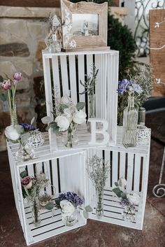 four white crates with flowers and frames on them