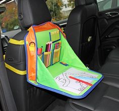 a child's book and pencils holder in the back seat of a car