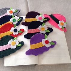 an open book with felt hats and flowers on it