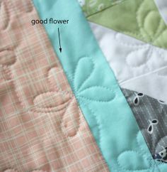 a close up view of a quilt with the words good flower on it and an arrow pointing