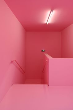 an empty room with pink walls and stairs