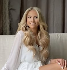 a woman sitting on top of a white couch