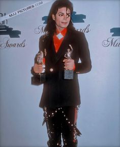 michael jackson holding two awards in his hands