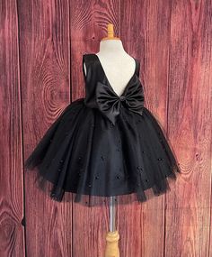 Little Darln Boutique  Our enchanting Knee Length flower girl dresses are sure to turn heads! This beautiful elegant sophisticated dress is handmade, the bodice consists of Black Bridal Satin with a sowed in sash at the waist, the back of the dress consists of an open V-back with a hidden zipper. The big bow is detachable. The skirt consists of 4 Black layers of tulle with the top layer consisting with sowed in pearl beads. The fifth layer is made of lining with crinoline for fullness.  This dress is perfect for any occasion!  Dress Is Pictured with a petticoat NOT INCLUDED https://www.etsy.com/listing/1316417982/white-knee-length-petticoat-wedding?click_key=41cb8b0ae4587efa582b0a433f3f5e0cde12aec0%3A1316417982&click_sum=af1df37b&ref=shop_home_active_1 Visit our store, more items to come! Black And White Wedding Flower Girl, Black Dress For Girls Kids, Flower Girl Black Dress, Black Dress For Kids, Flower Girl Dresses Black, Baby Black Dress, Black Toddler Dress, Fall Wedding Flower Girl, Black Kids Dress