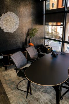 an empty conference room with chairs and a table in front of a large window that looks out onto the street