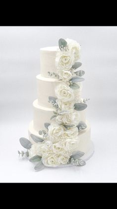 a wedding cake with white flowers and leaves