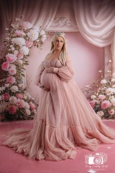 a pregnant woman wearing a pink gown and crown