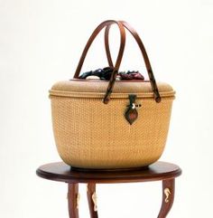 a wicker basket sitting on top of a wooden stand