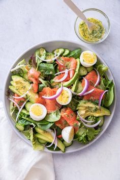 a salad with hard boiled eggs, tomatoes and lettuce