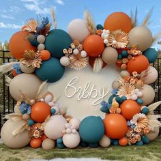 an outdoor display with balloons and flowers in the shape of a baby's name