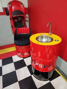 a red and yellow sink in a room with black and white checkered flooring