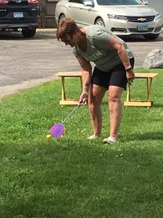 a woman is playing with her dog in the grass