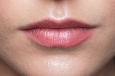 a woman's lips with pink lipstick on the bottom half of her face, close up