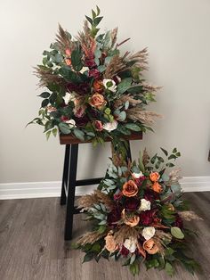 two tall floral arrangements sitting on top of a chair