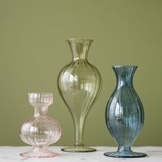 three glass vases sitting on top of a table