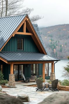 a house with a metal roof next to a lake