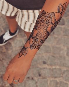 a woman's foot with a tattoo on it and flowers in the middle of her leg