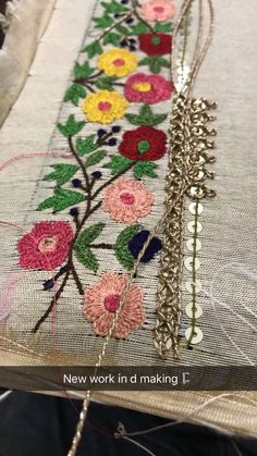 a close up of a piece of fabric with flowers on it and a chain hanging from the side