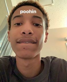 a young man with the word poohn written on his forehead in front of him