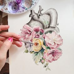 a drawing of a heart with flowers and a faucet next to it on top of a table